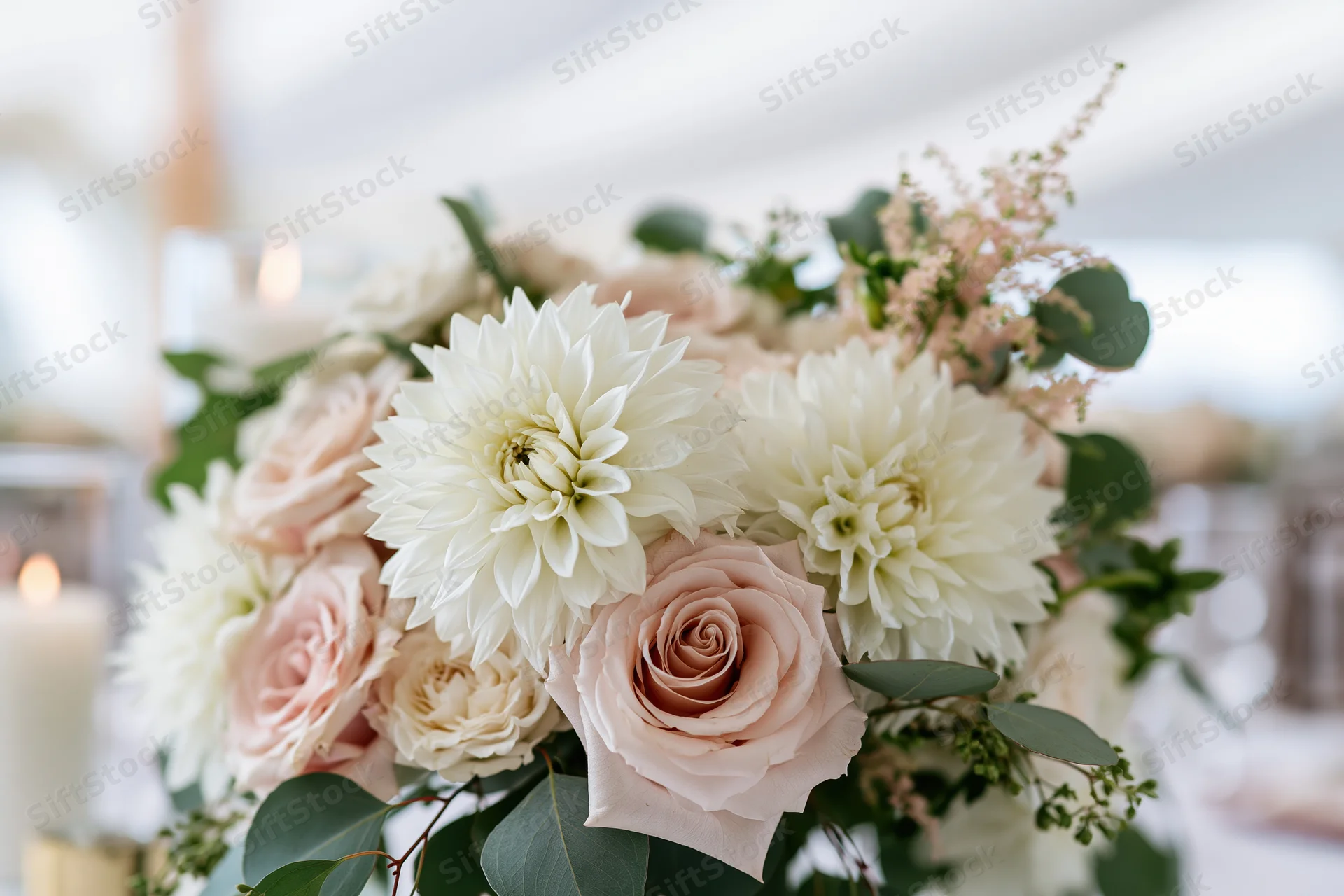 Wedding centerpiece with white dahlias and blush roses on a table