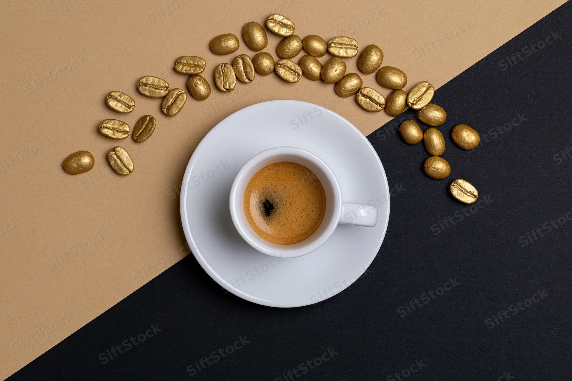 White espresso cup with crema on saucer surrounded by golden coffee beans on beige and black surface