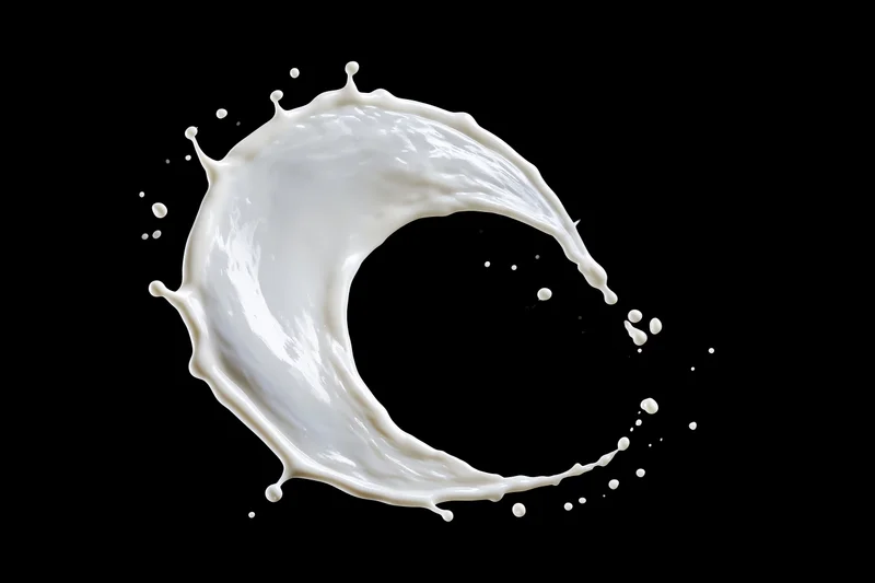 White milk splash frozen midair in sweeping arc shape against black background
