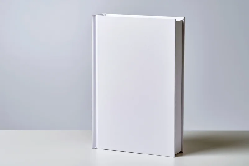 Blank white hardcover book standing upright on a flat surface