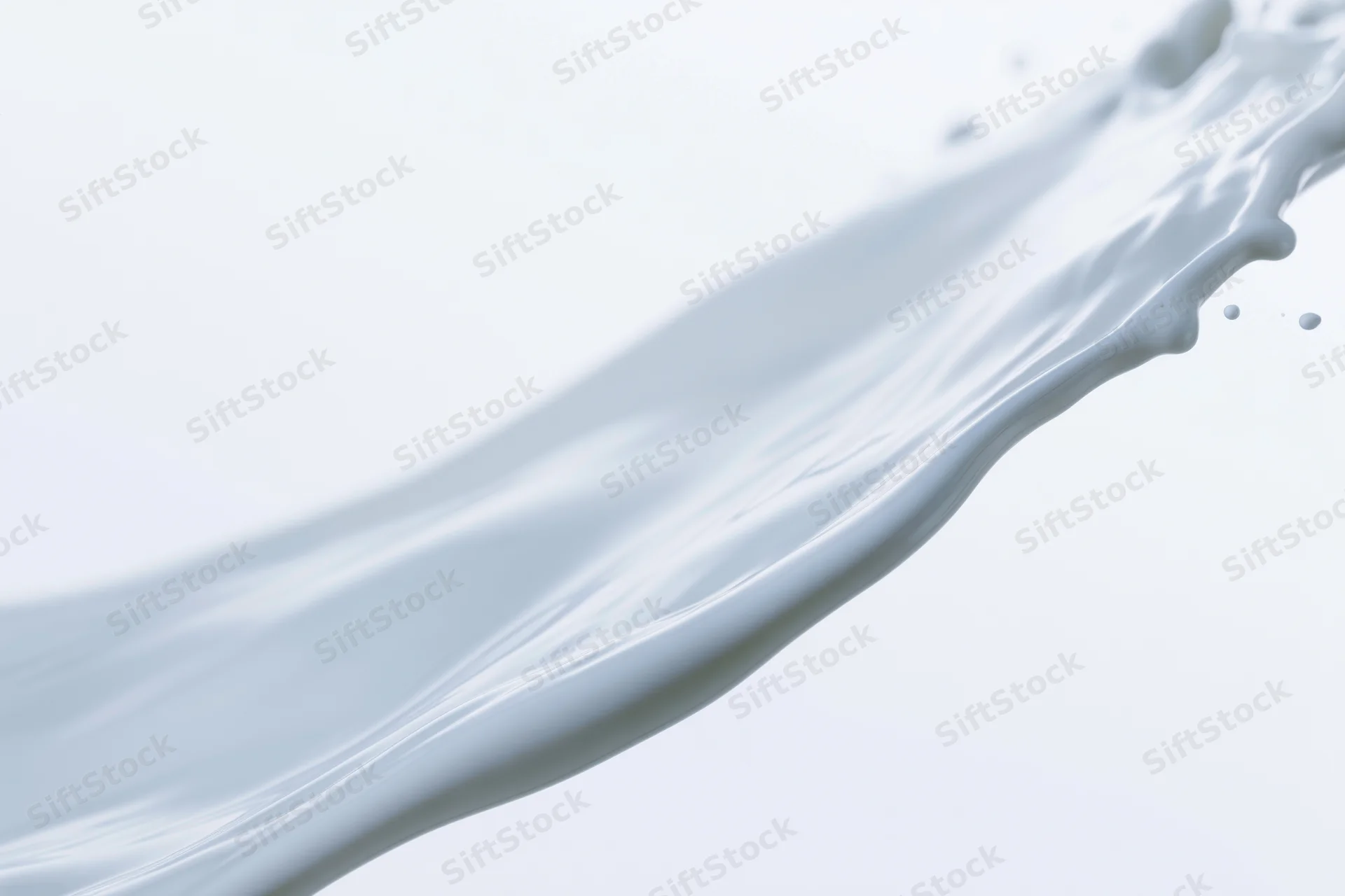 Flowing wave of white milk mid-splash captured in motion against a plain white background