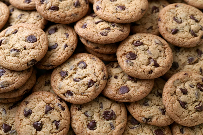 Large pile of freshly baked chocolate chip cookies stacked
