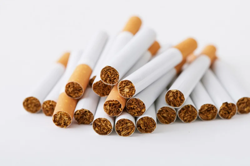 Unlit cigarettes piled together on a white surface