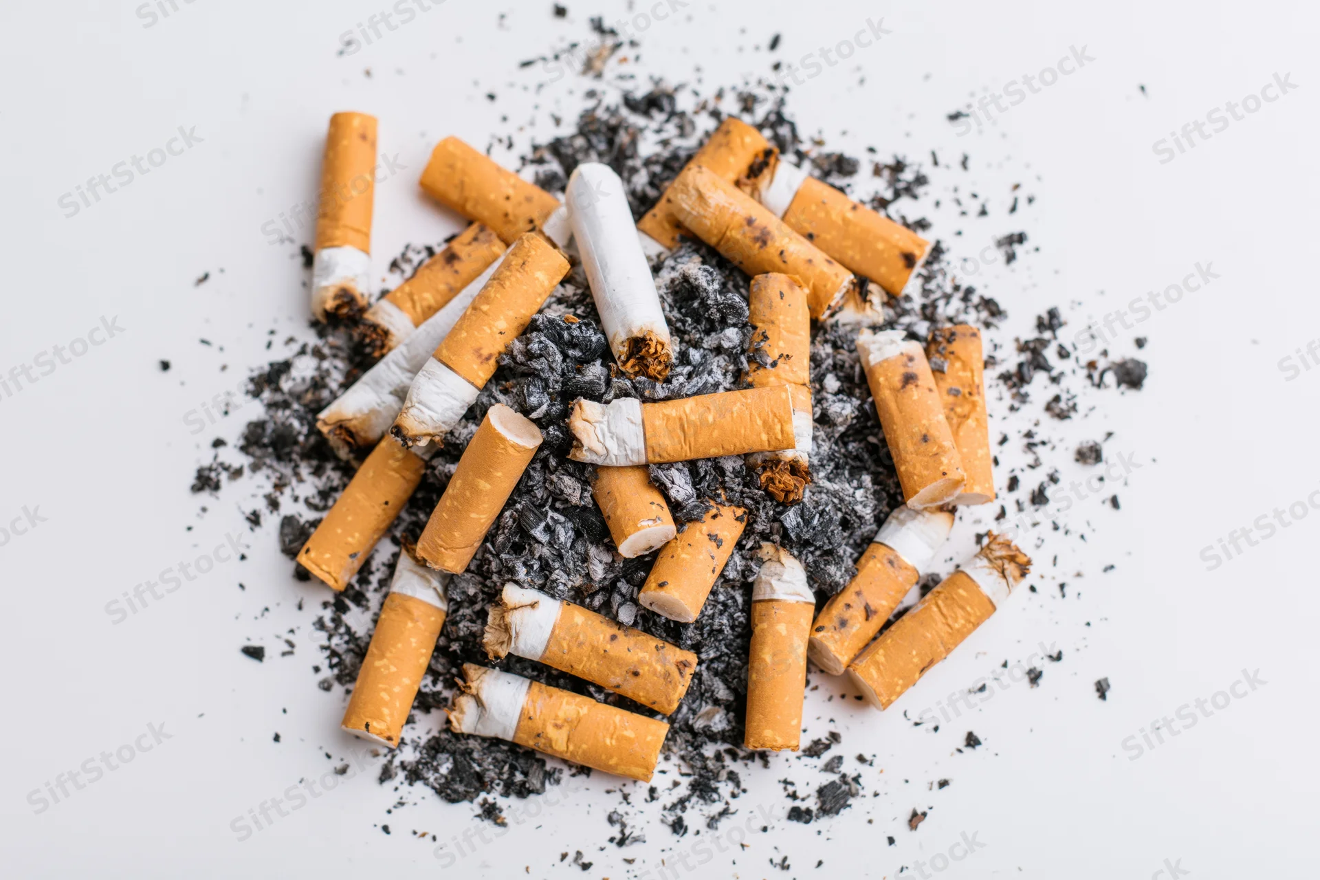 Cigarette butts and ash scattered on a white surface