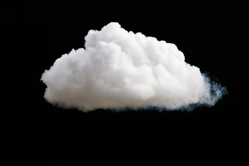 Fluffy white cumulus cloud isolated against black background