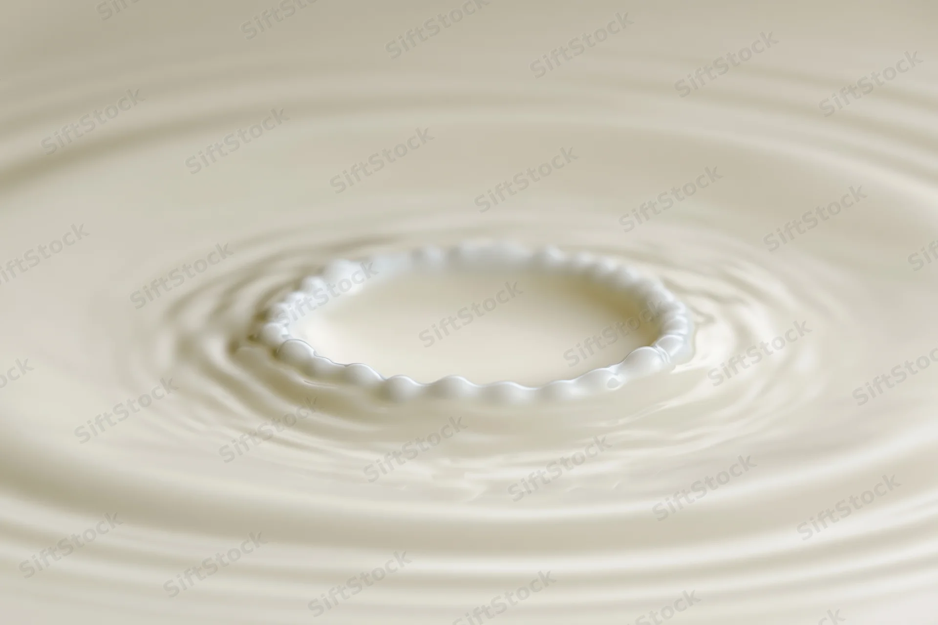 Milk drop creating crown splash on smooth surface