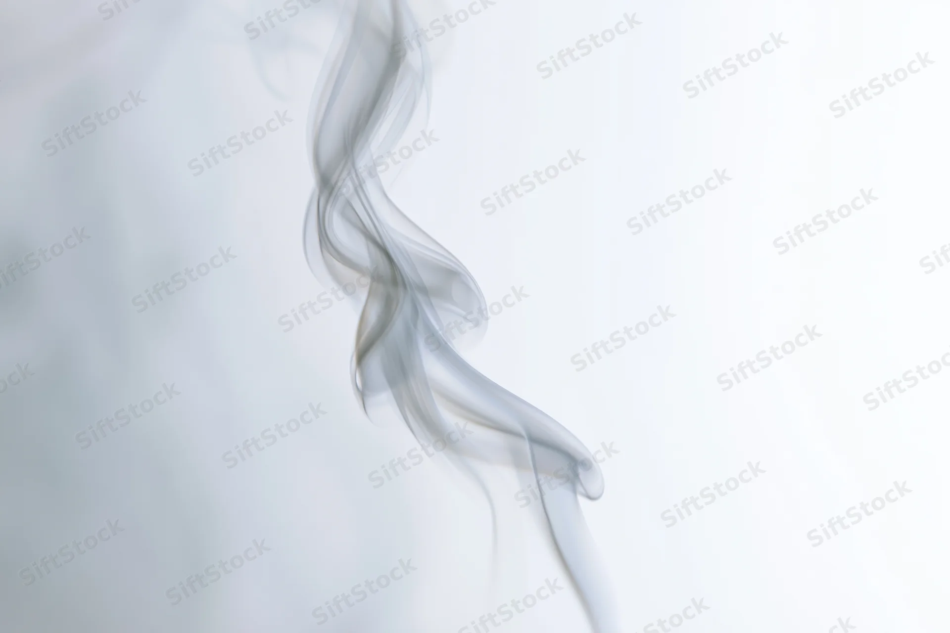 A single wisp of white smoke curling and twisting upward against a plain white background