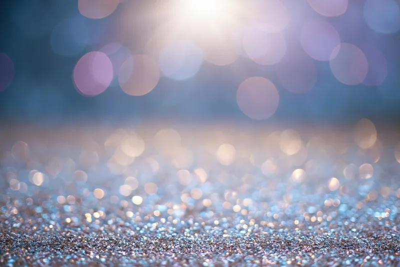 Abstract bokeh background with scattered light orbs and glittery surface