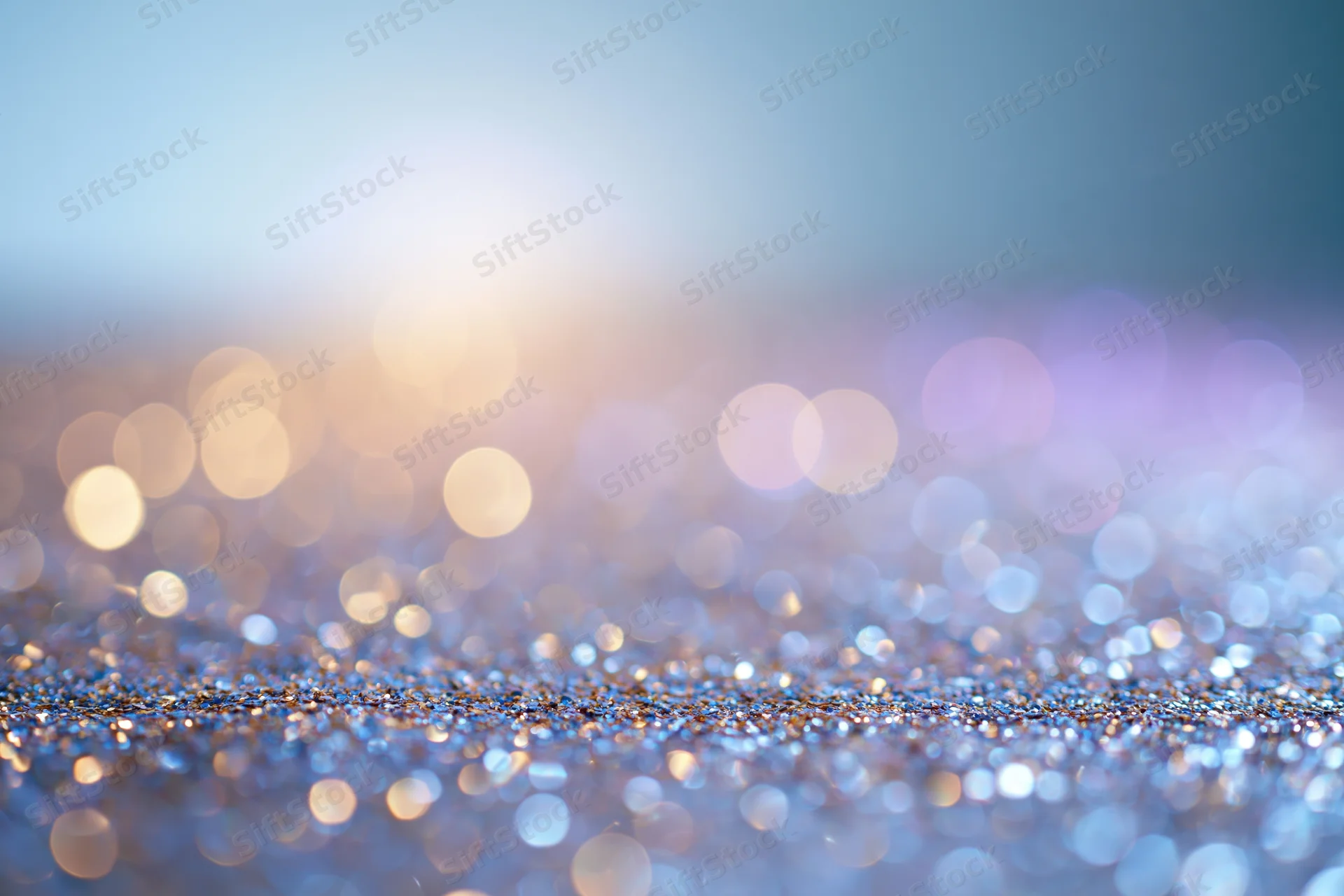 Abstract bokeh background with scattered light orbs and glittery surface