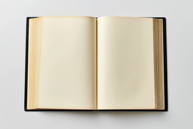 Open hardcover book with blank yellowed pages on white background