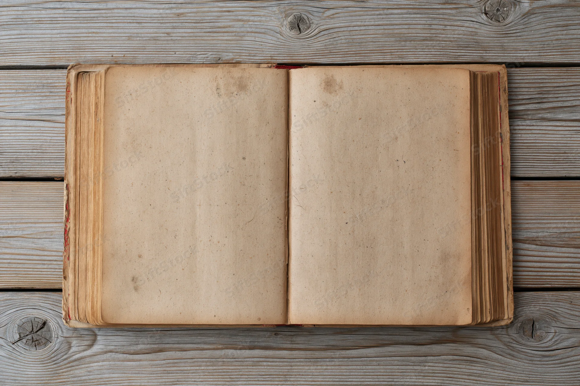 Open vintage book with blank yellowed pages lying flat on wooden surface