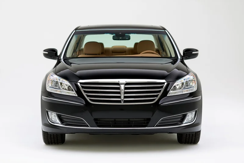 Black luxury sedan viewed straight-on from front in studio setting