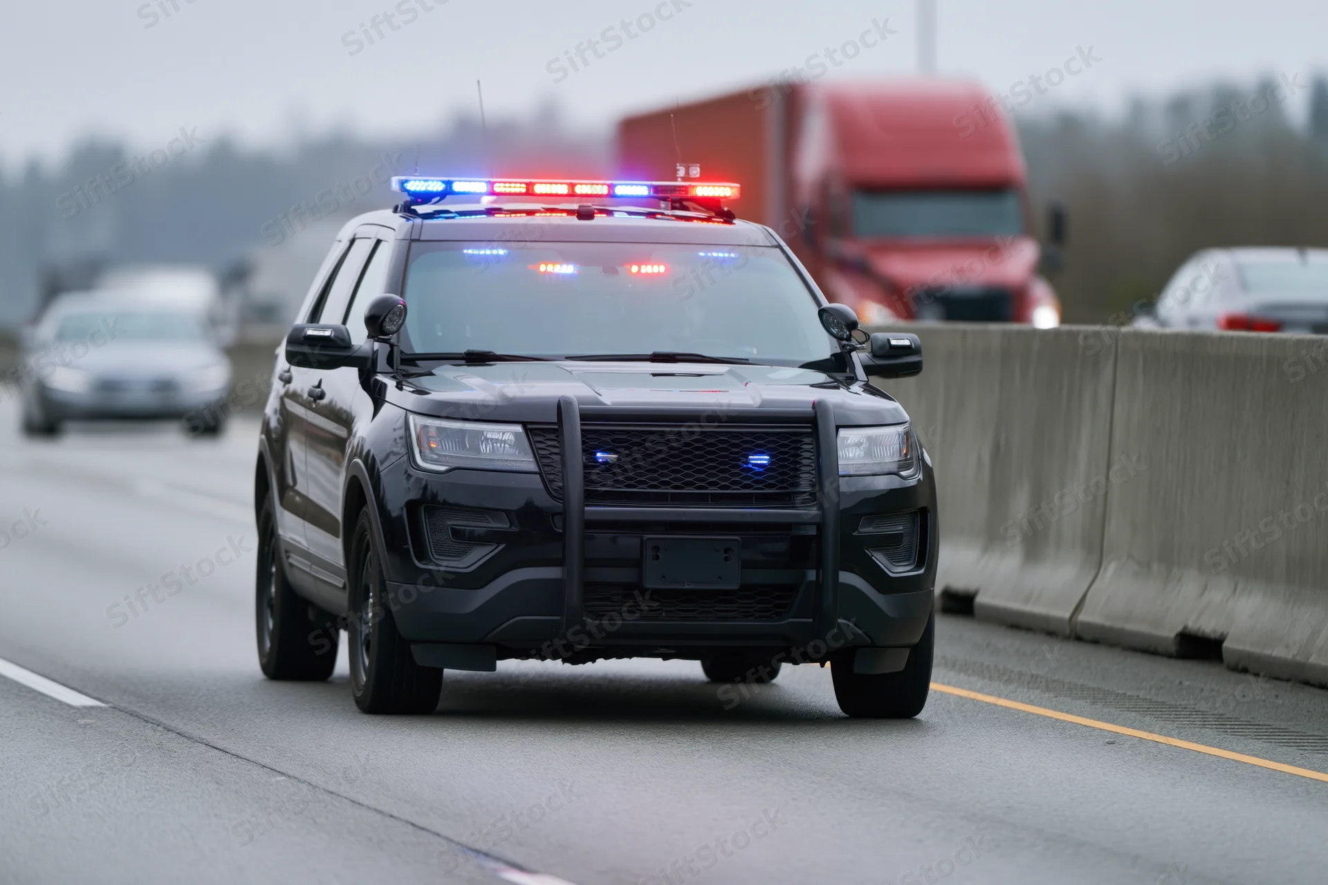 Black police suv with flashing roof lights and push bumper driving on highway