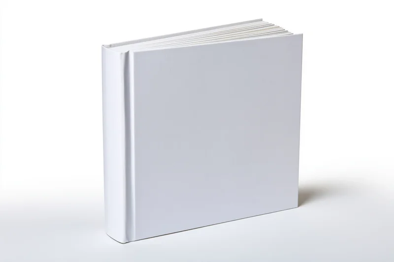 Blank white hardcover book standing upright on a white surface with no text or design on the cover