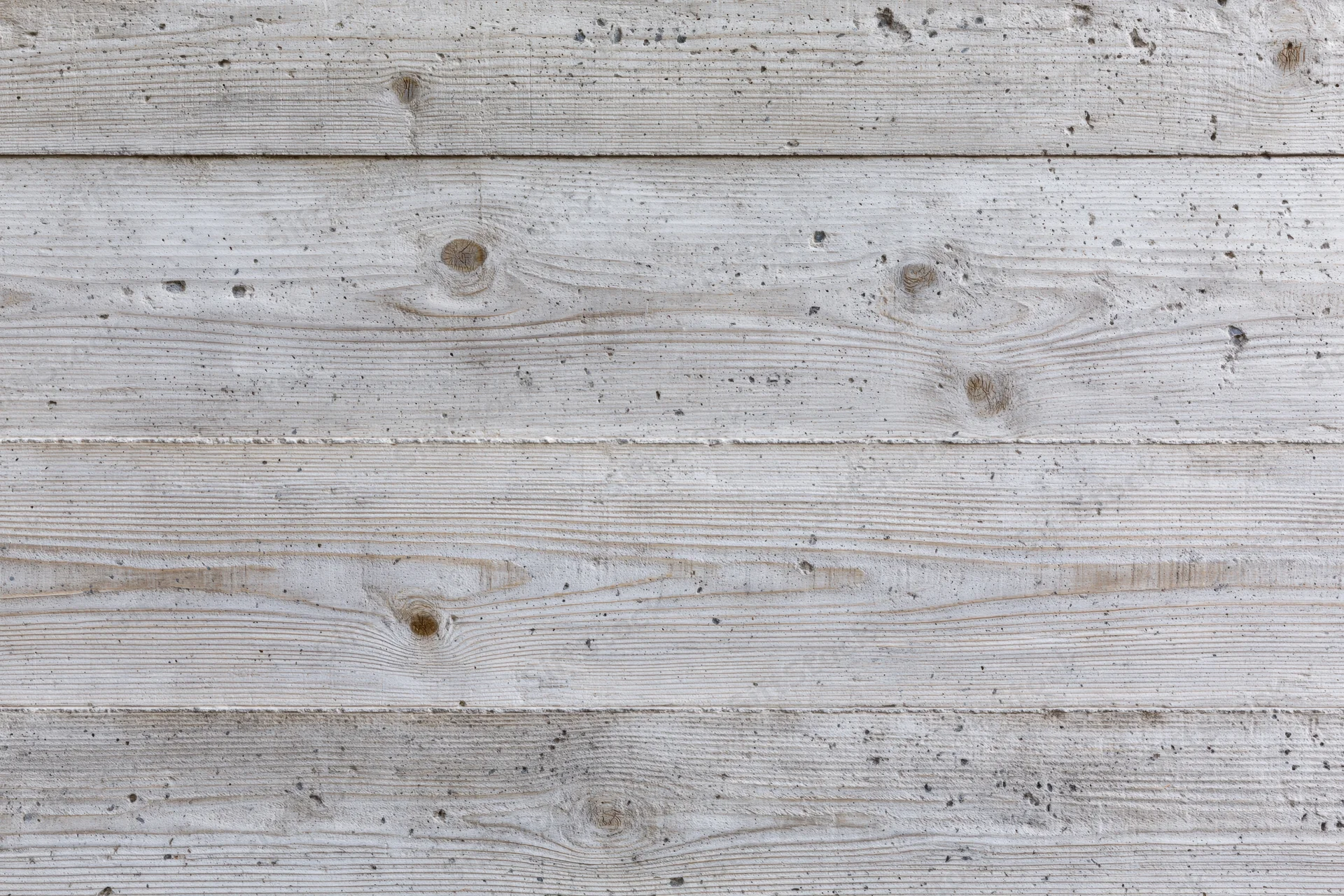 Board-formed concrete wall surface with horizontal texture and weathered finish