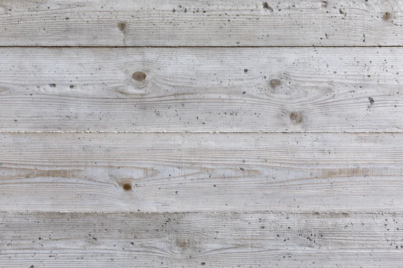 Board-formed concrete wall surface with horizontal texture and weathered finish