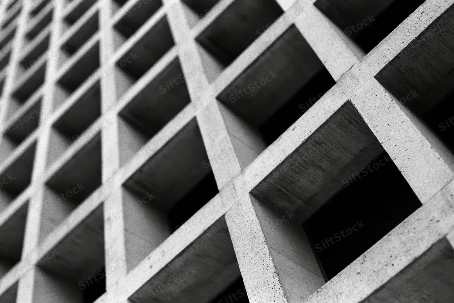 Close-up of a concrete grid structure on a building facade viewed at an oblique angle