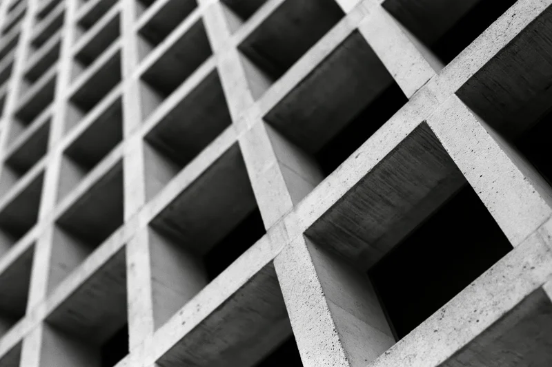 Close-up of a concrete grid structure on a building facade viewed at an oblique angle