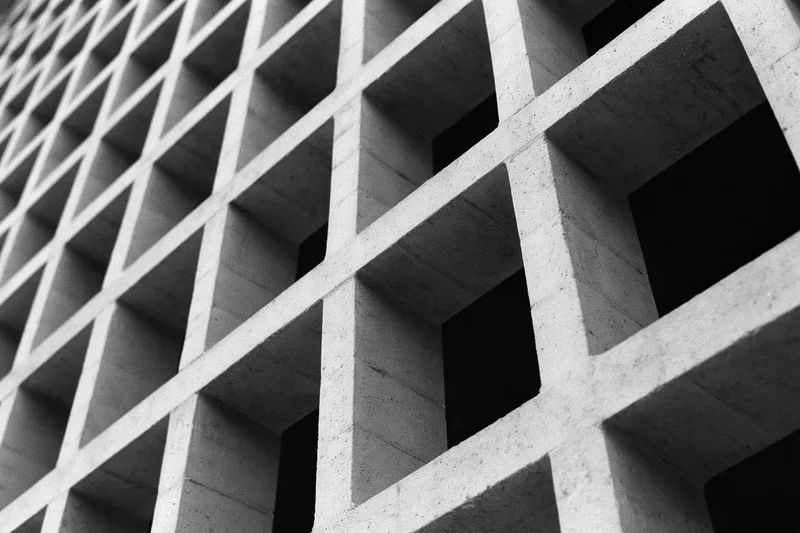 Close-up of a brutalist concrete grid structure viewed at an oblique angle