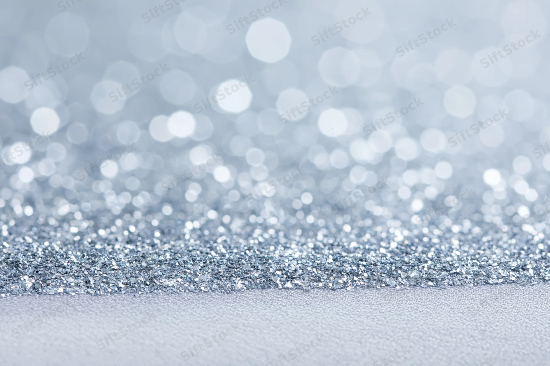 Close-up of silver glitter fabric with bokeh background