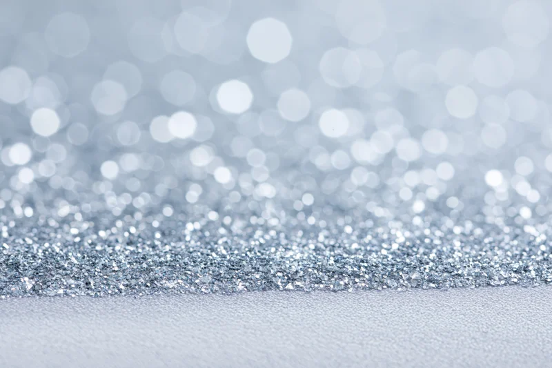 Close-up of silver glitter fabric with bokeh background