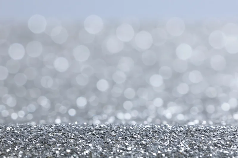 Close-up of silver glitter fabric surface with bokeh background