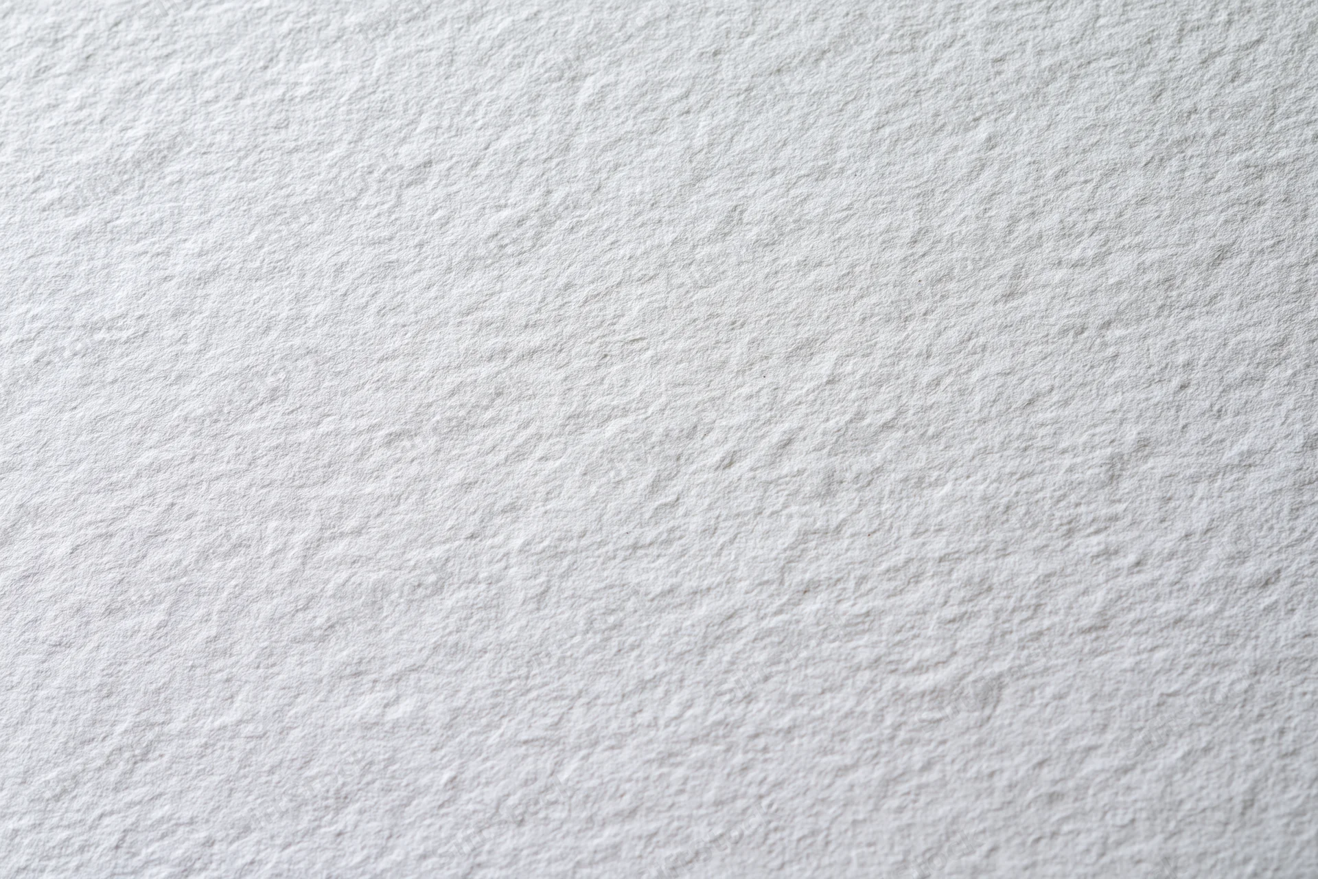 Close-up of a blank white textured paper sheet lying flat as a background