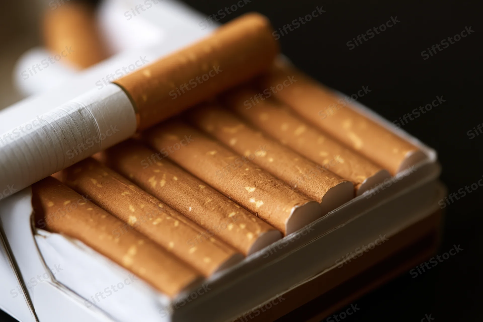 Open cigarette pack with one cigarette pulled out, close-up view