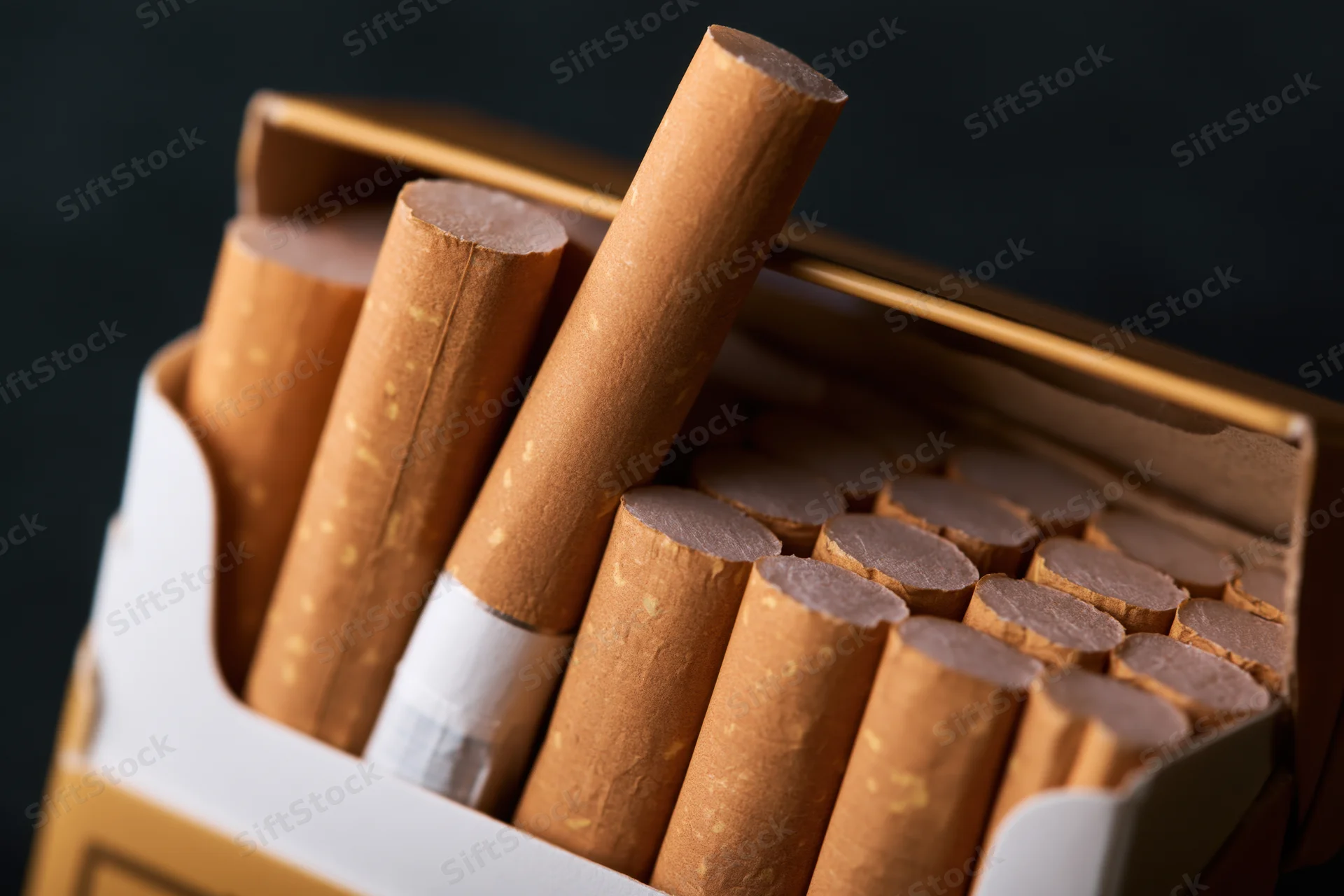 Open cigarette pack with one cigarette pulled out, close-up view