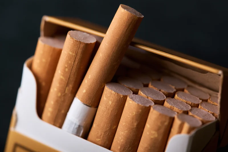 Open cigarette pack with one cigarette pulled out, close-up view