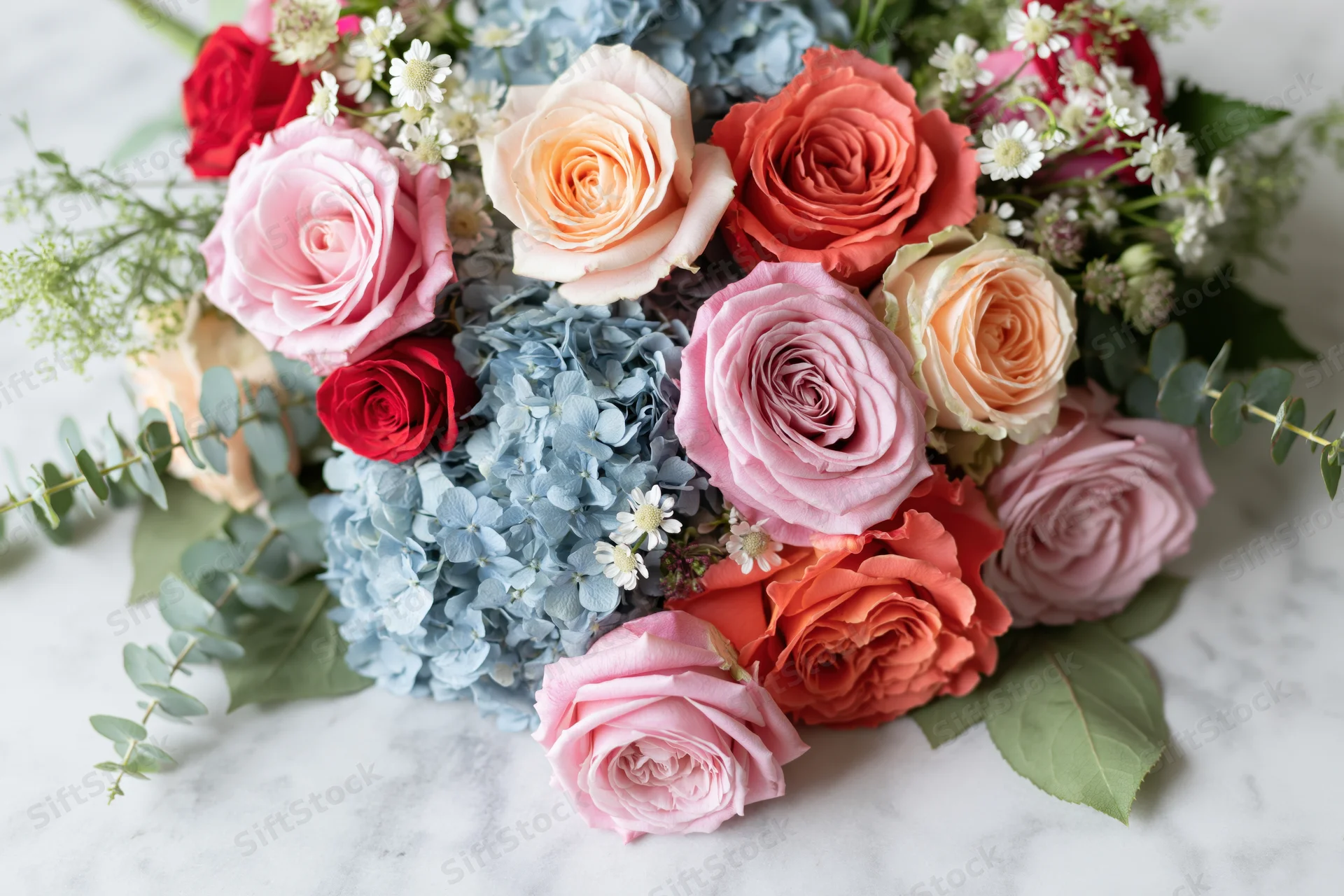 Mixed floral bouquet with roses and hydrangea on marble surface