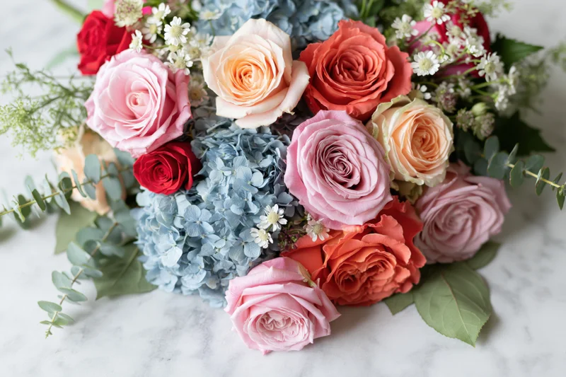 Mixed floral bouquet with roses and hydrangea on marble surface