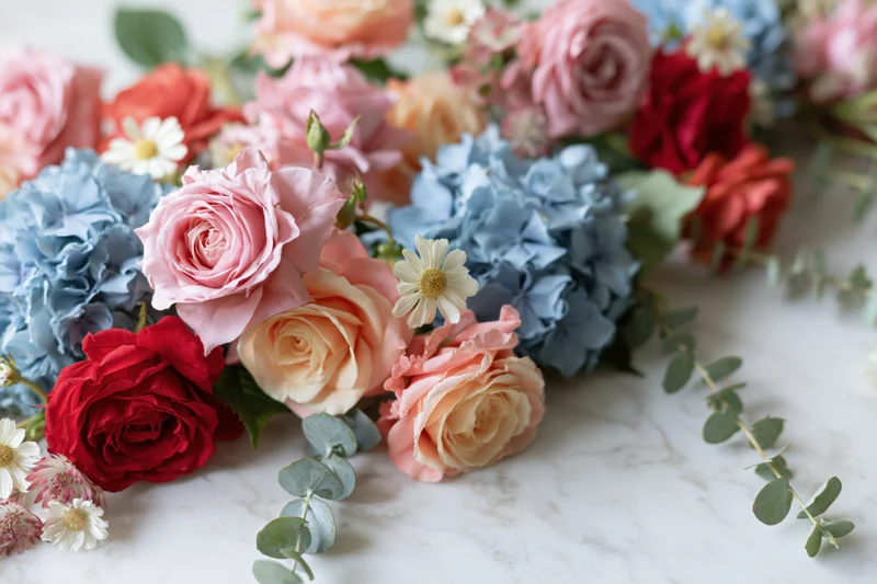 Mixed floral arrangement with roses, hydrangeas and eucalyptus on marble surface