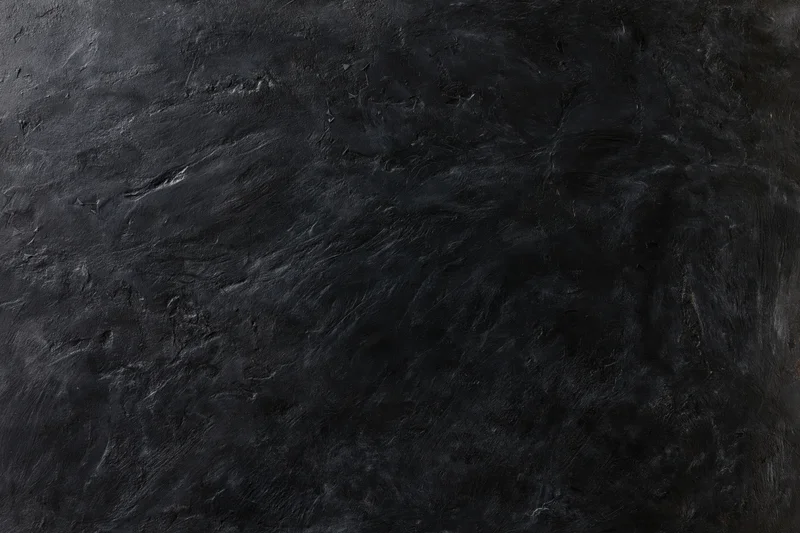 Dark weathered concrete wall surface filling entire frame