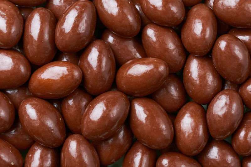 Glossy chocolate-covered almonds filling the frame
