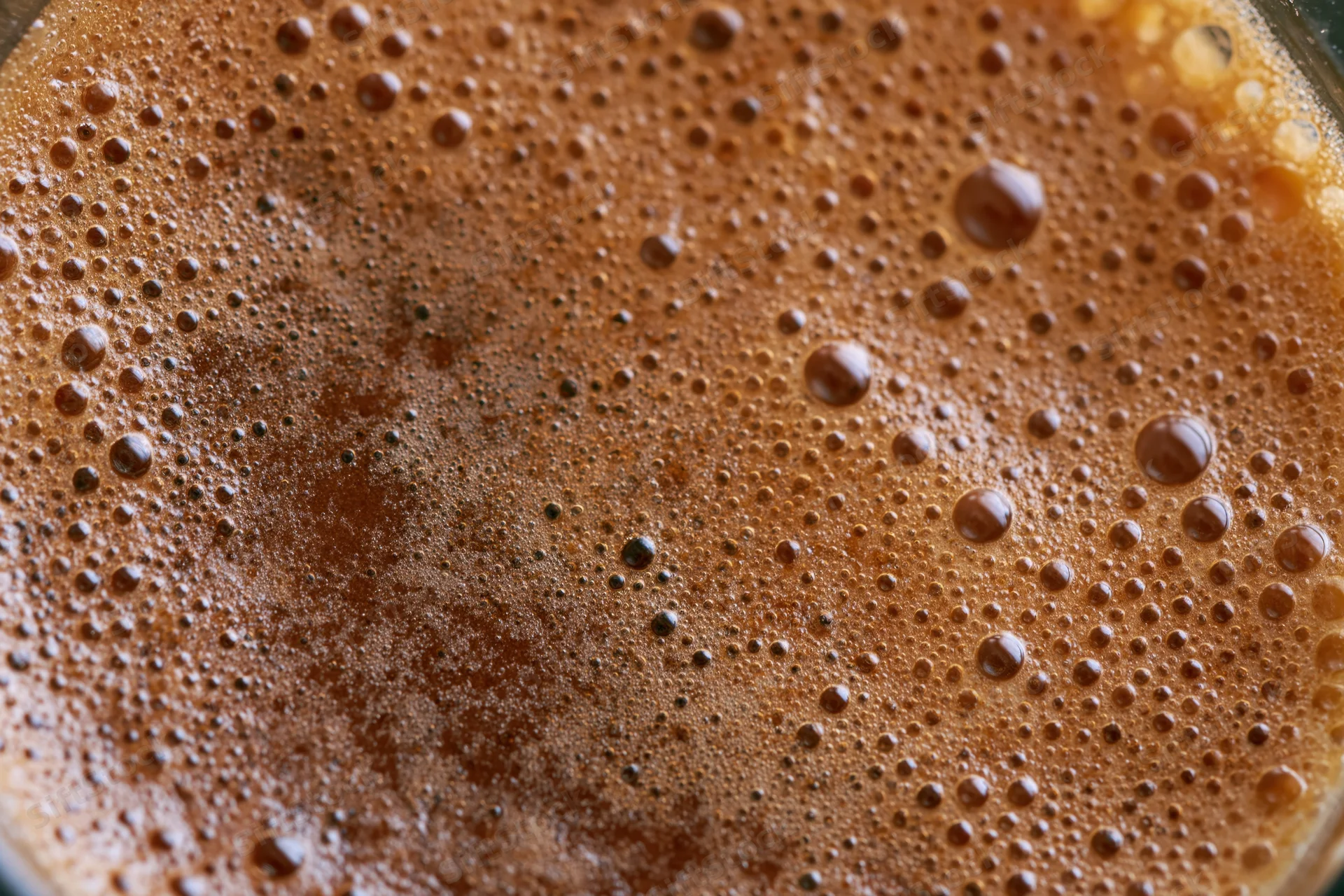 Close-up of freshly brewed black coffee with frothy bubbles on the surface