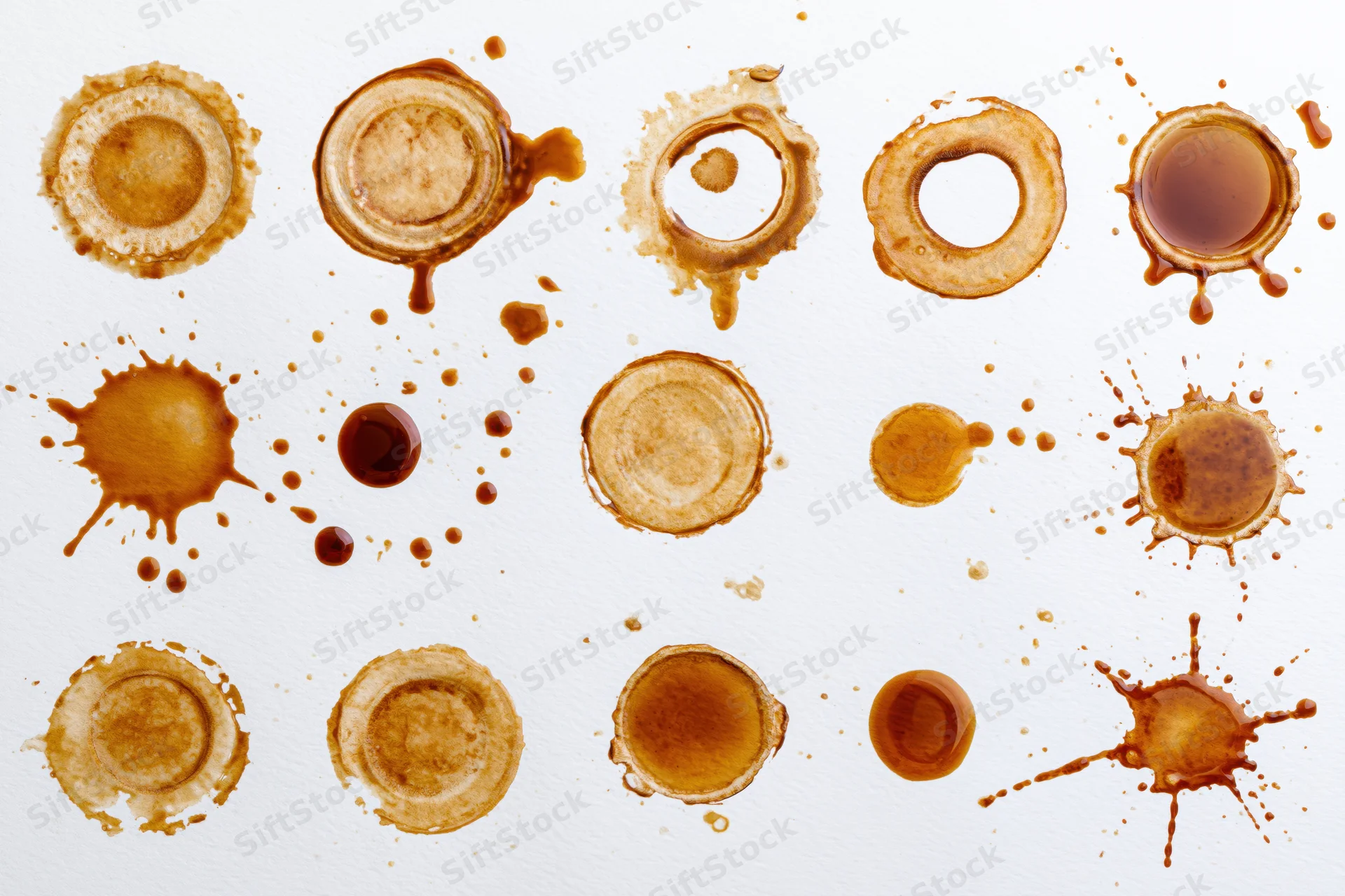 Coffee stains and splatter marks arranged in rows on white background