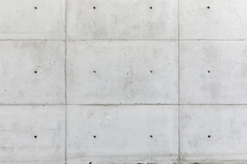 Flat concrete wall surface with grid pattern and bolt holes
