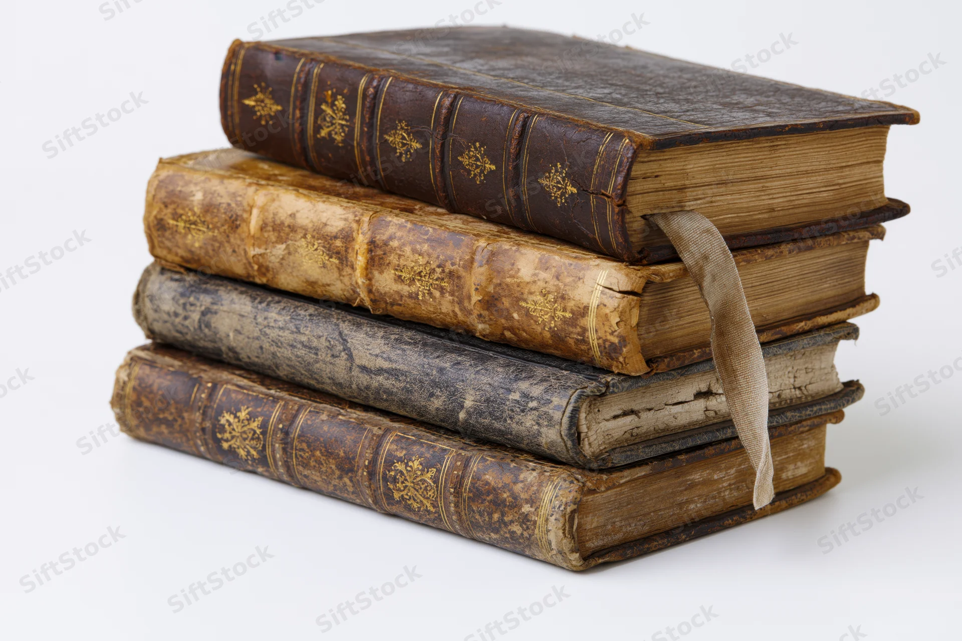Four antique leather-bound books stacked horizontally with spines visible on white background