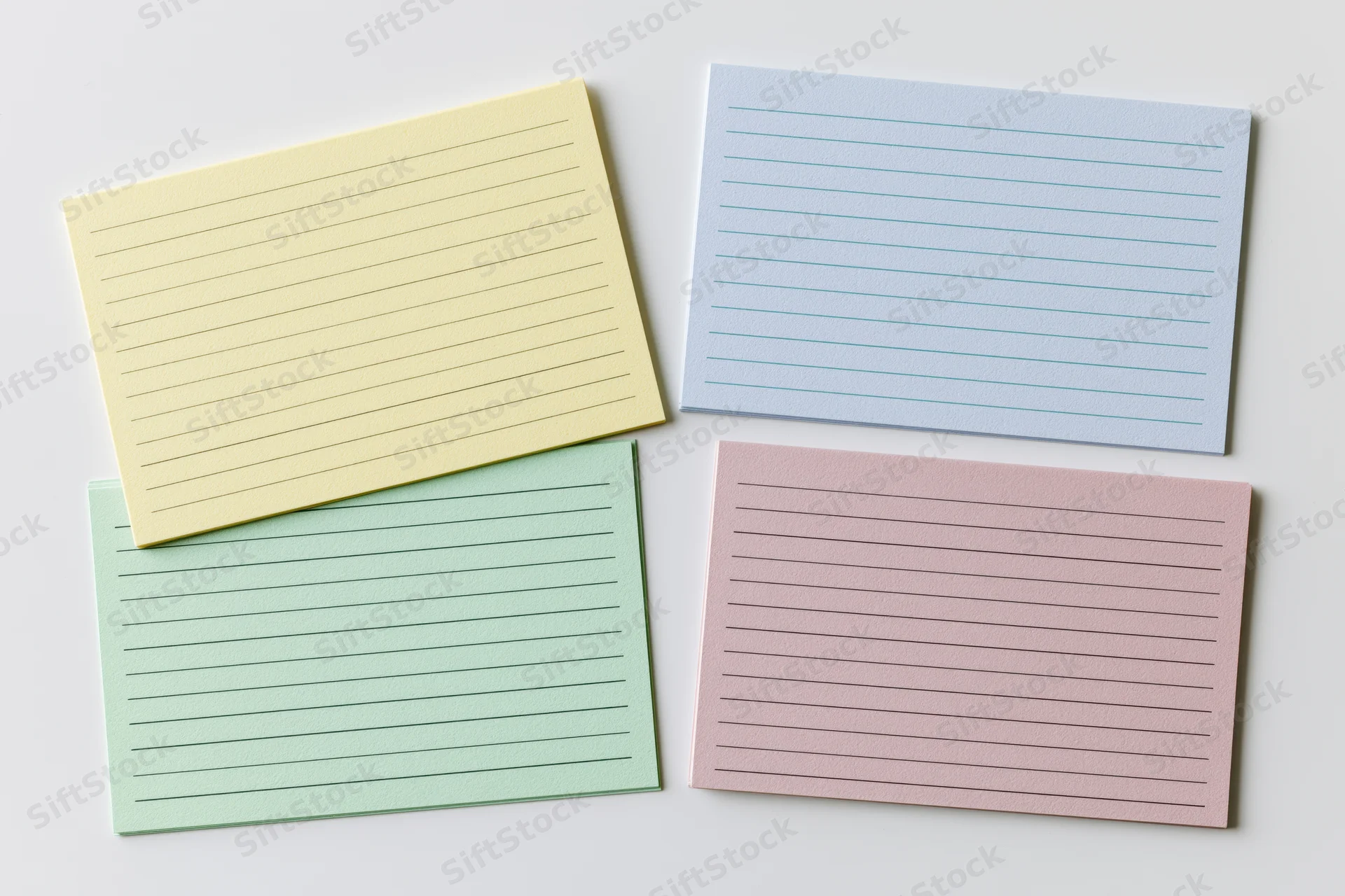 Four blank lined index cards arranged in a two-by-two grid on a white surface