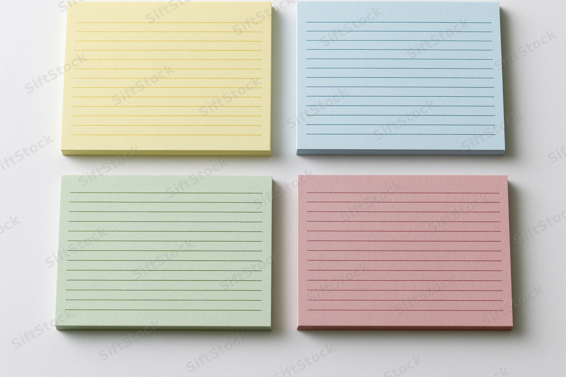 Four blank lined index cards arranged in a two-by-two grid on a white surface