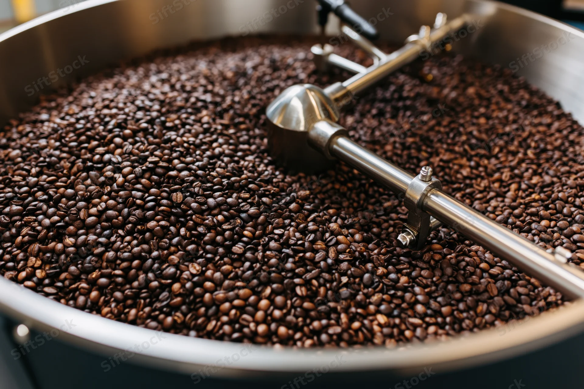 Roasted coffee beans cooling in a large industrial roasting drum