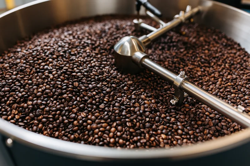 Roasted coffee beans cooling in a large industrial roasting drum