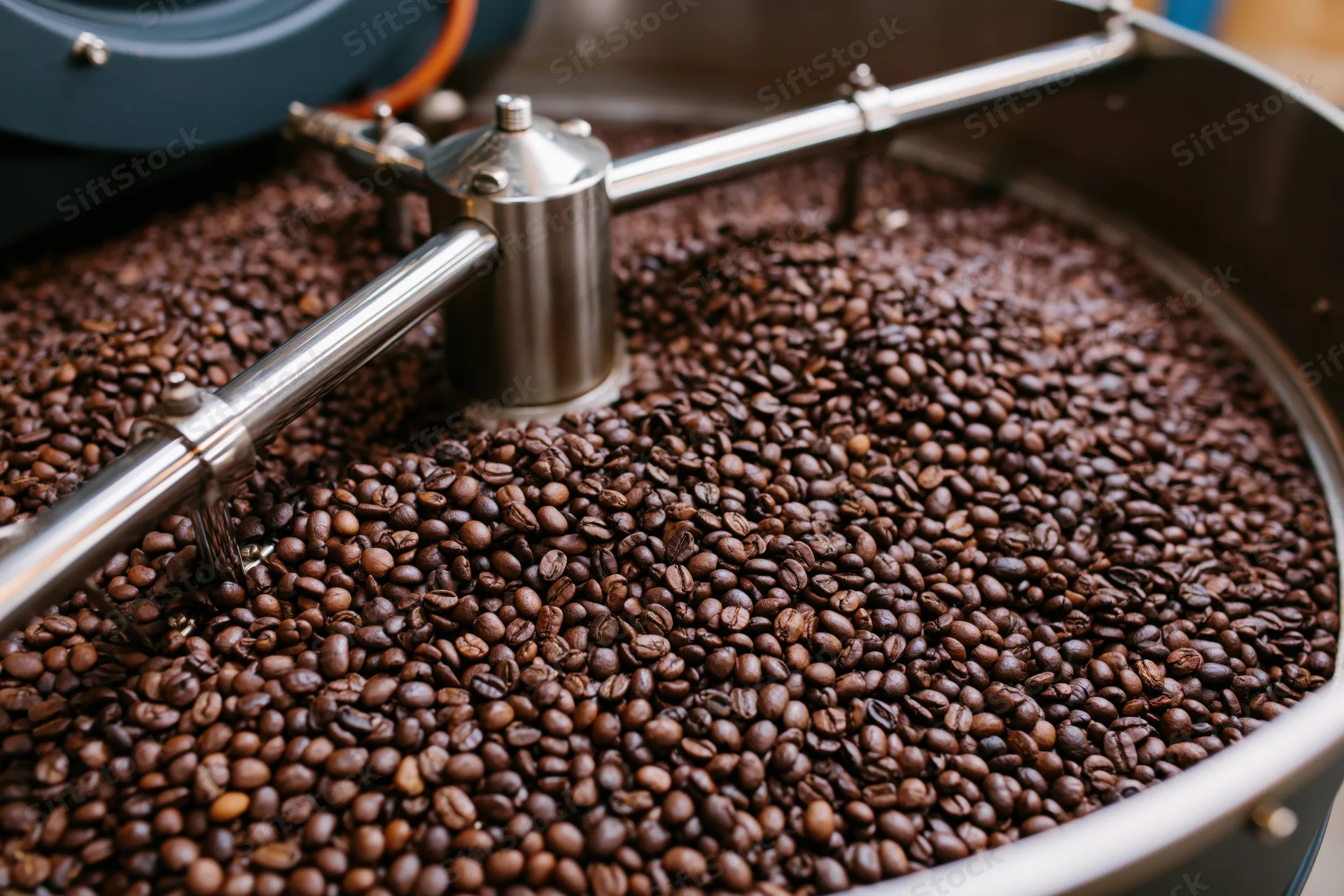 Roasted coffee beans cooling in a large industrial roasting drum