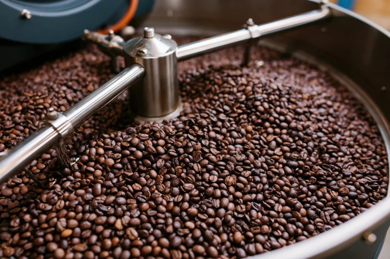Roasted coffee beans cooling in a large industrial roasting drum
