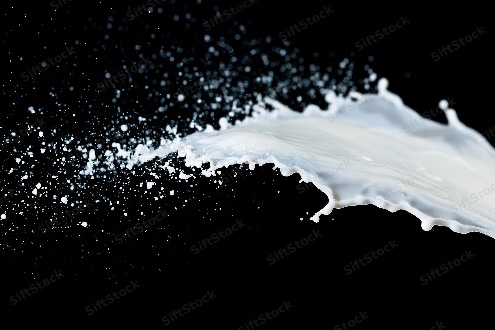 Milk splash mid-air diagonal against black background