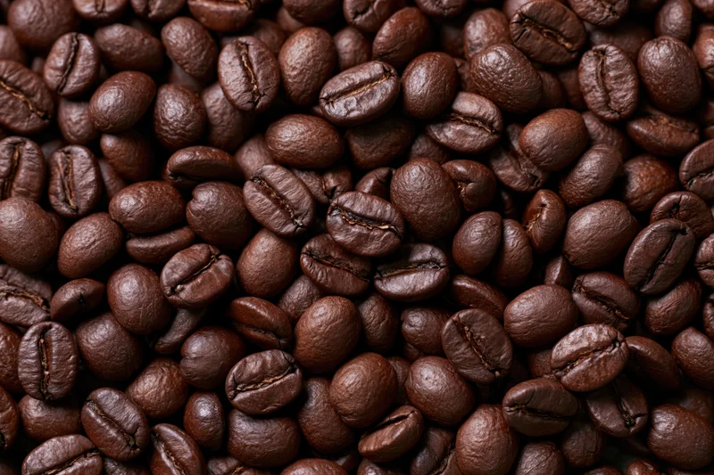 Dark roasted coffee beans filling the frame in a close-up view