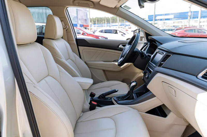 Beige leather seats and dashboard in a modern compact SUV interior viewed from passenger side door