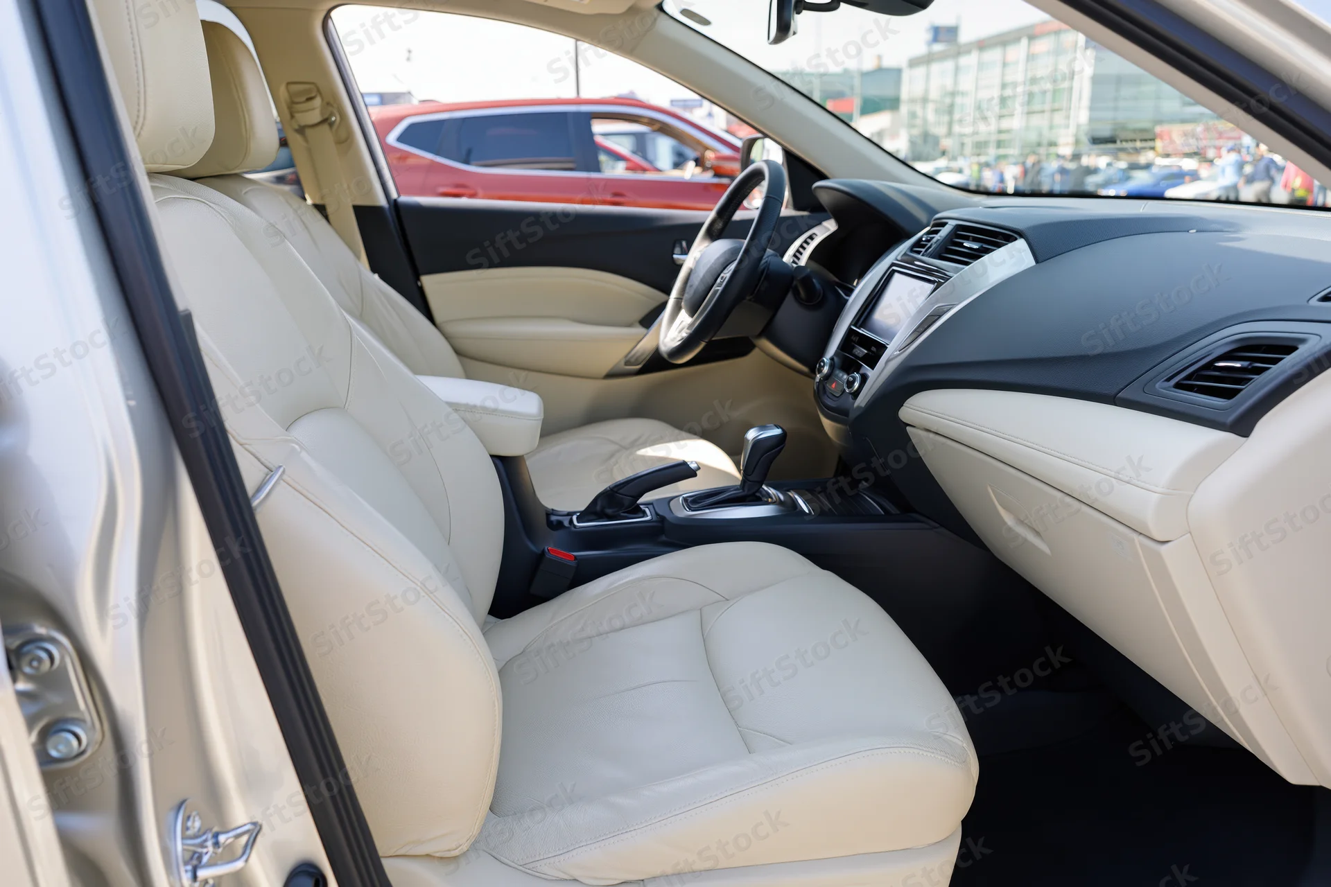 Interior of a modern compact SUV viewed from open passenger side door showing beige leather seats and dashboard controls