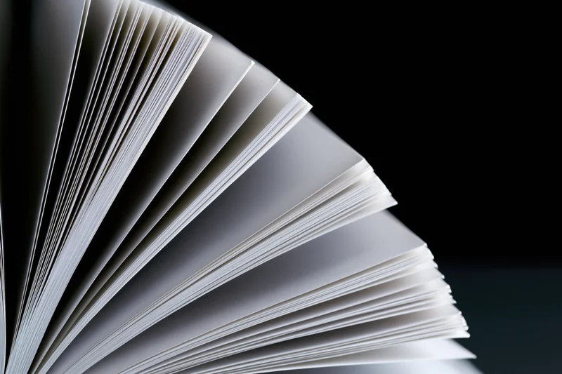 Open book with pages fanned in wide arc against black background